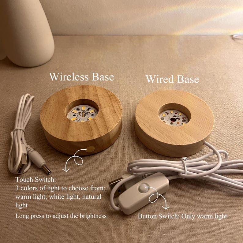 Two wooden light bases, one wireless and one wired, on a beige surface.